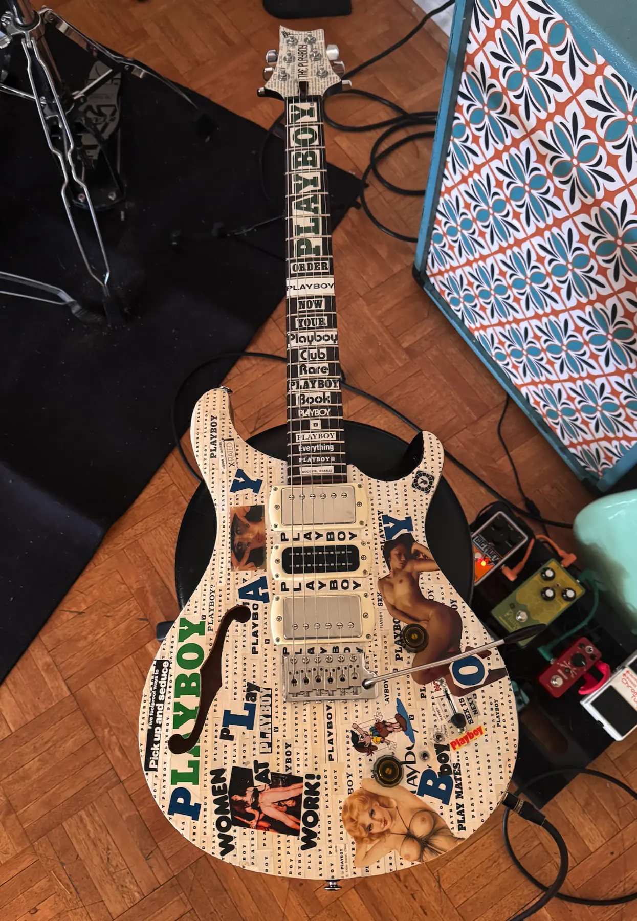 Front of commissioned white collage guitar with artwork across the body, fretboard and headstock