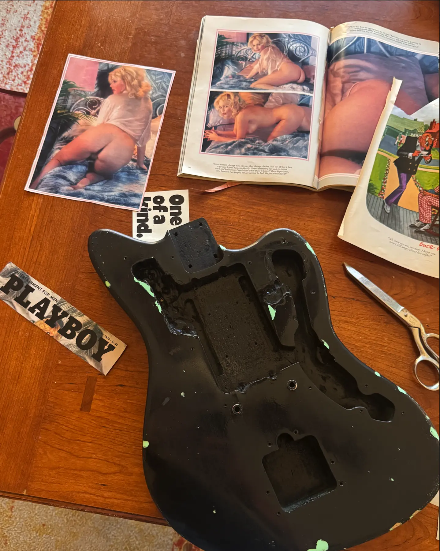 Guitar body, vintage print material and scissors during the art process